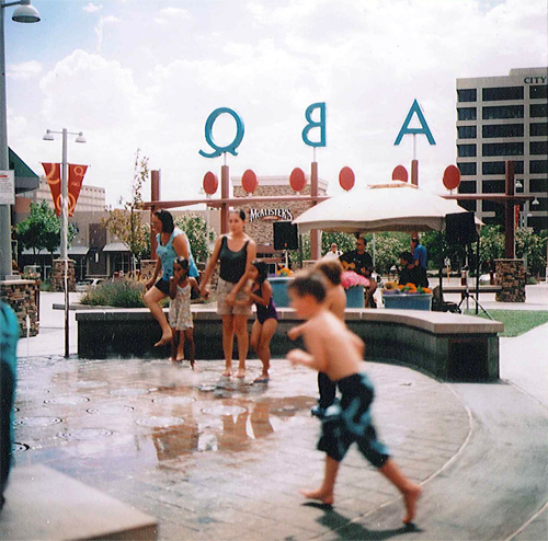 Parents and children playing in the ABQ Uptown fountain