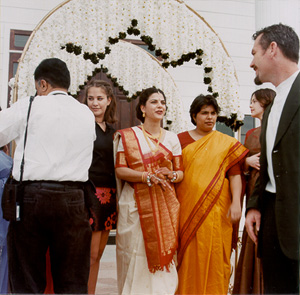 Mora greets guests in front of the flower arch